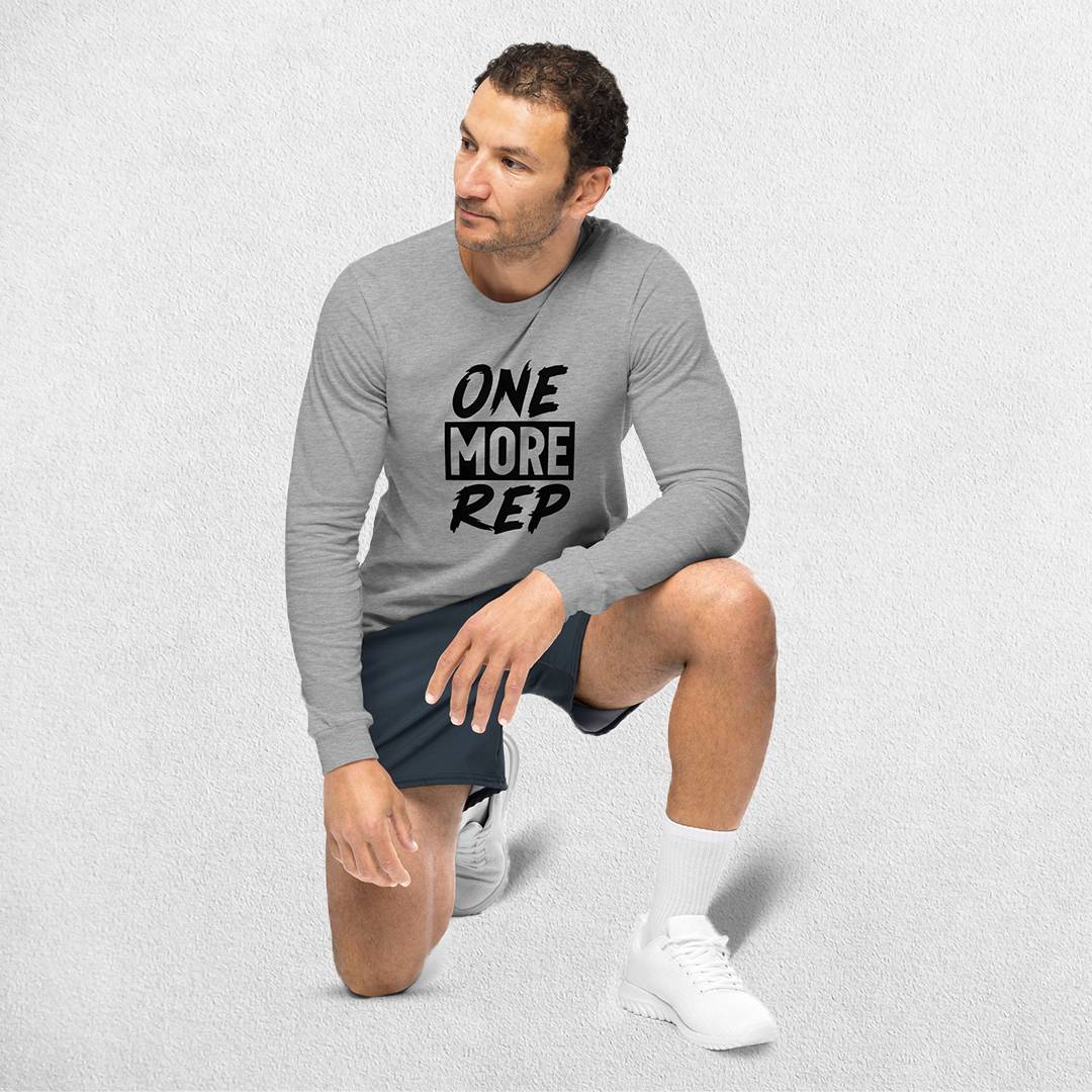 Sitting Model wearing the Athletic Heather GPW One More Rep Unisex Motivational Long Sleeve Tee.