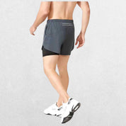 "Back view of the GPW High-Performance Men’s Running Shorts in dark grey, showing the stylish cut, rear pocket, and durable stitching against a professional studio setting."