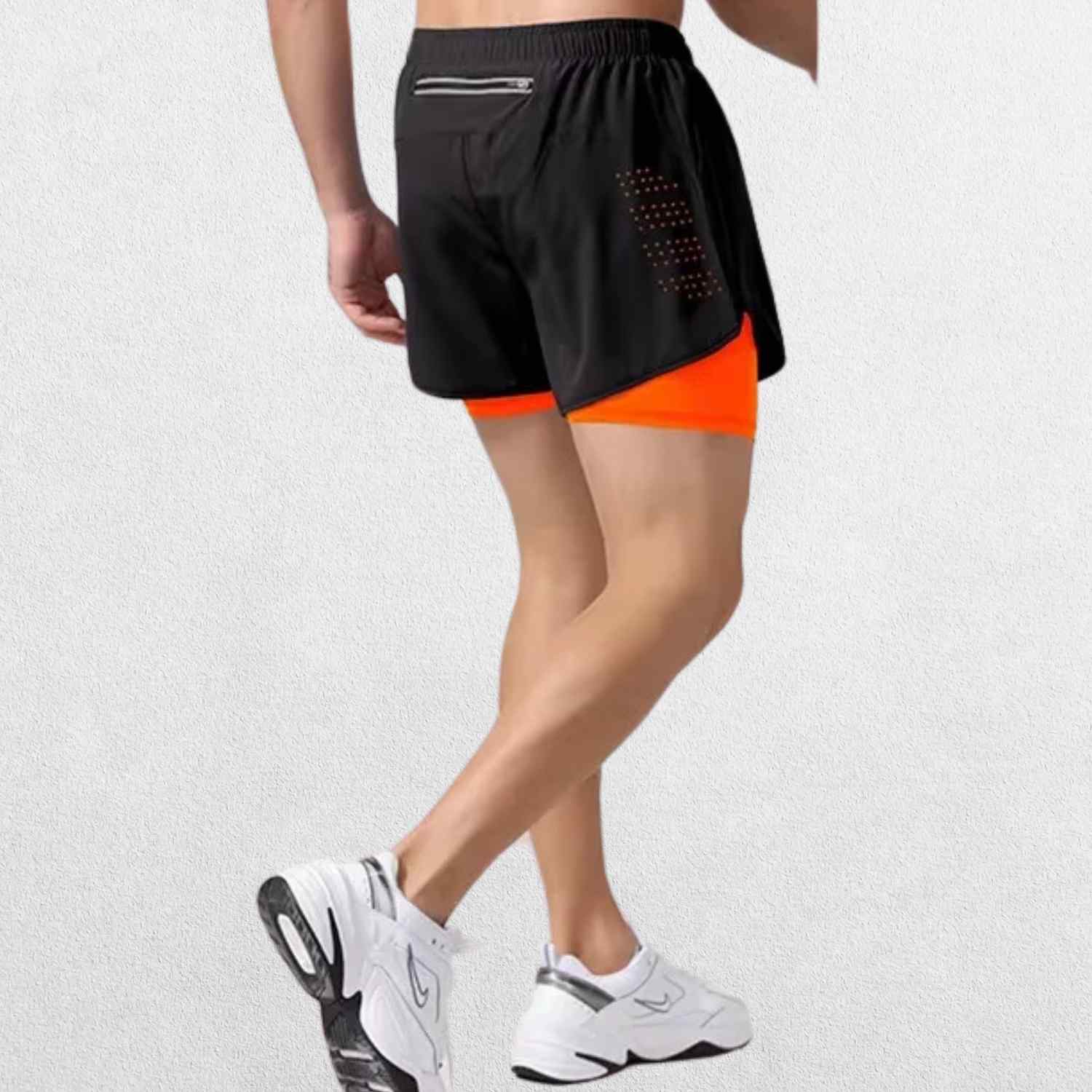 Back view of the GPW High-Performance Men’s Running Shorts in fluorescent orange, showcasing the sporty cut, reflective details, and ergonomic fit against a clean studio setting."