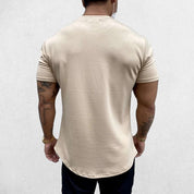 Close-up of Beige GPW Men's Fit Summer Gym T-Shirt - Bodybuilding Streetwear Tee in a studio background