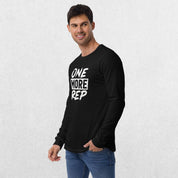 Model wearing the Black GPW One More Rep Unisex Motivational Long Sleeve Tee with jeans in studio background.