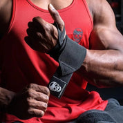 Weightlifter securing Black wrist wraps during a heavy powerlifting session