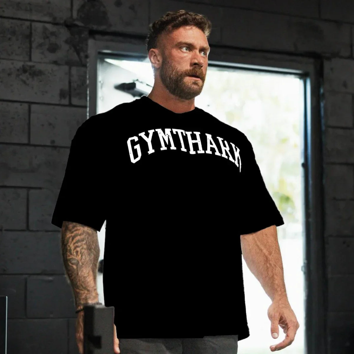 Side Pose of Model in a gym weaing Black Loose Fit Oversized Gym Tee – Heavyweight Cotton, Premium Comfort & Strength