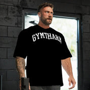 Side Pose of Model in a gym weaing Black Loose Fit Oversized Gym Tee – Heavyweight Cotton, Premium Comfort & Strength