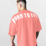 Model wearing Coral Pink GPW Oversized T-Shirt, styled for streetwear and gym.