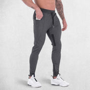 Side pose of model wearing Practical zipper pocket securely holding a phone in GPW athletic trousers.