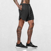 Side pose of Model Wearing Dark Grey GPW Men's 2-in-1 Running Shorts for Gym & Fitness Workouts