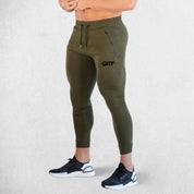 Side Pose of Model Wearing Dark Olive Green Breathable Men’s Training Joggers with Adjustable Drawstring and Secure Pockets
