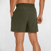 Back Close-up of Dark Olive Green GPW Men's Lightweight Quick-Dry Workout Shorts with Pockets in a studio background