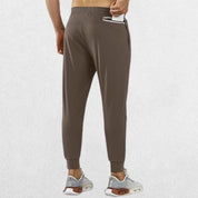 Close-up of brown athletic trousers with zipper pocket