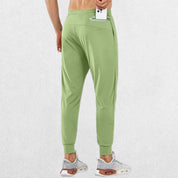 Model placing phone in back zipper pocket of GPW Men's Lightweight Trousers, showcasing secure storage for essentials