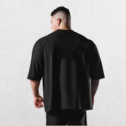 Casual styling of a BLack men’s gym shirt in studio background