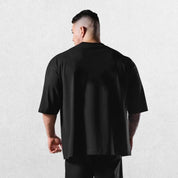 Casual styling of a BLack men’s gym shirt in studio background