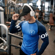 Model wearing GPW Men’s Bodybuilding Long Sleeve Shirt in blue, showcasing moisture-wicking fabric and slim fit in the gym.