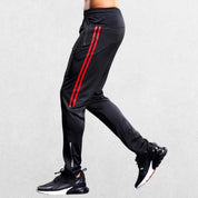 Red GPW gym joggers featuring sporty lines and zipper pockets.