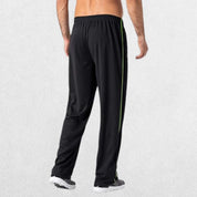 GPW Men’s Lightweight Loose Fit Open Bottom Mesh Athletic Trousers Black Back View in Studio Background.