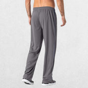 GPW Men’s Lightweight Loose Fit Open Bottom Mesh Athletic Trousers Dark Grey Back View in Studio Background.
