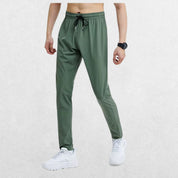 GPW Men's Slim Fit Pencil Pants in light green, front view displaying the modern athletic design with a soft studio background.