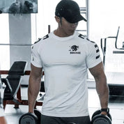 Model in gym wearing white GPW Men's Quick-Dry T-Shirt, showcasing comfort and quick-dry features