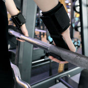 Athlete using Black integrated wrist wraps for wrist support during a heavy pull-up session.