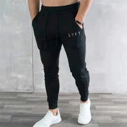 Model wearing GPW men’s black breathable pants with hand in pocket, showcasing casual and athletic style.