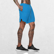Side View Of model wearing Light Blue GPW Men's 2-in-1 Running Shorts with hands in pockets