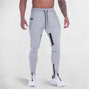 Front view of model wearing Light Grey GPW Men's Slim Fit Trousers with Zipper Pockets for Training