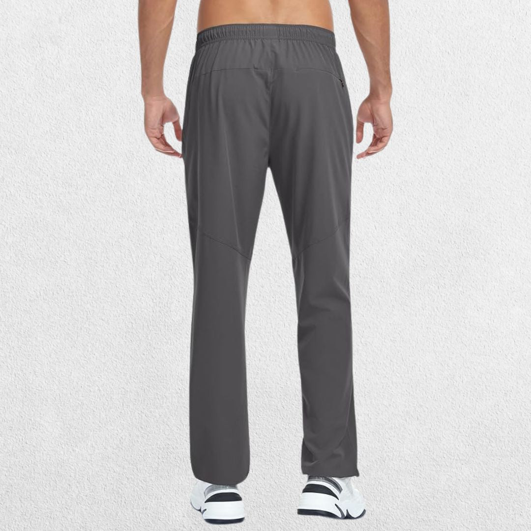 Men's Lightweight Quick-Dry Hiking Trousers in grey, showcasing back pocket details with a hand placed near the side, studio shot.