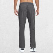 Men's Lightweight Quick-Dry Hiking Trousers in grey, showcasing back pocket details with a hand placed near the side, studio shot.