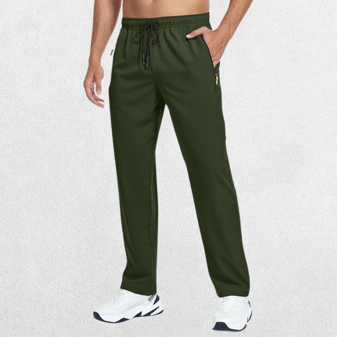 Men's Lightweight Quick-Dry Hiking Trousers in green, featuring a man placing a hand in the trouser pocket, studio shot.