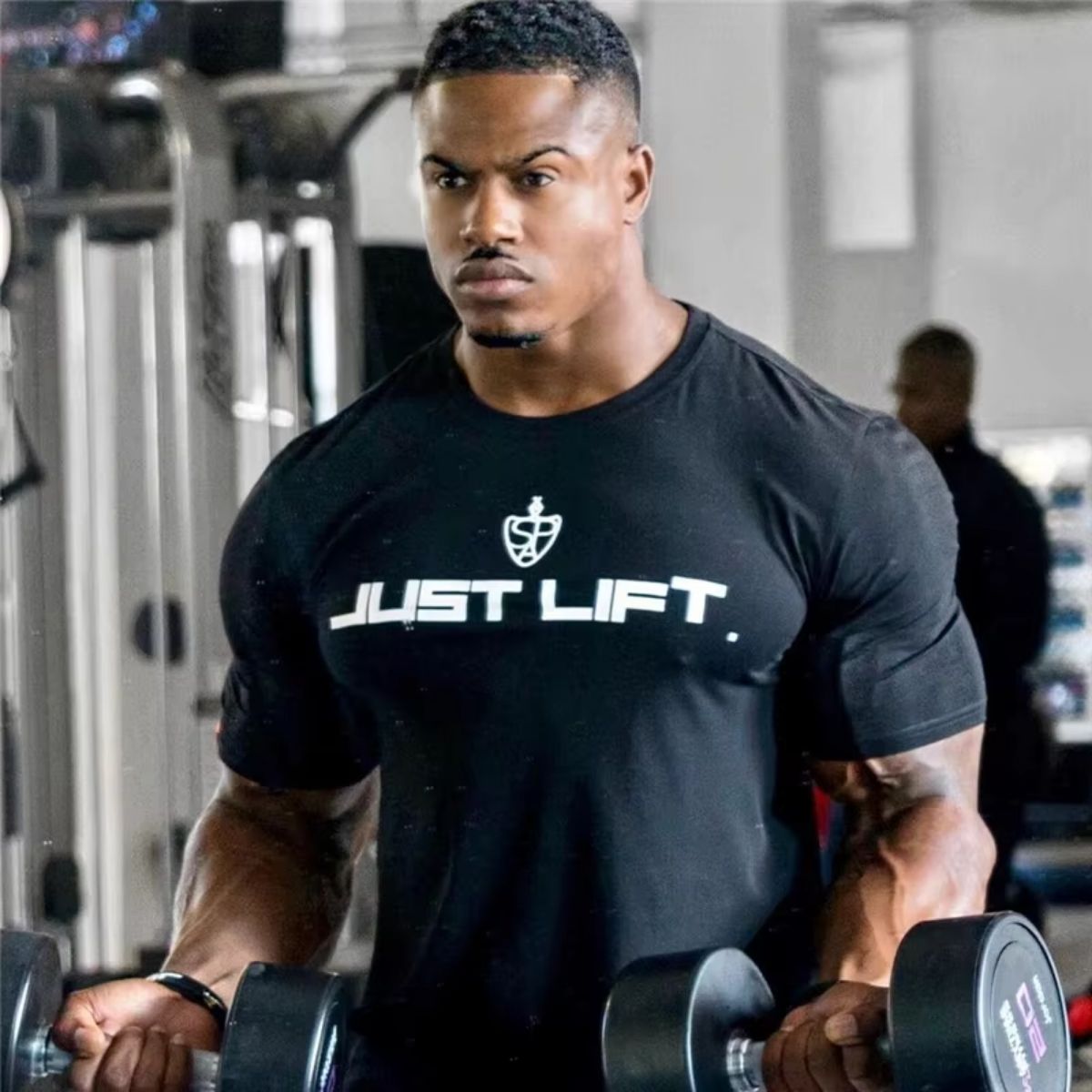 Man using gym equipment while wearing a black fitness cotton t-shirt.