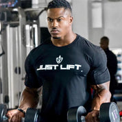 Man using gym equipment while wearing a black fitness cotton t-shirt.
