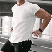 Model wearing a white quick-dry men's gym t-shirt, leaning into a stairs railing for a sleek and modern look.