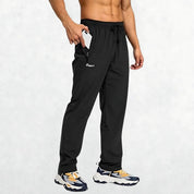 Men’s black athletic trousers with elastic waistband and zipper pockets for secure storage during workouts.