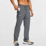 Dark grey men's athletic trousers with elastic waist and front zipper pockets, perfect for workouts.