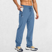 Front view of men's lichen blue athletic trousers with adjustable elastic waistband and secure zipper pockets for essentials