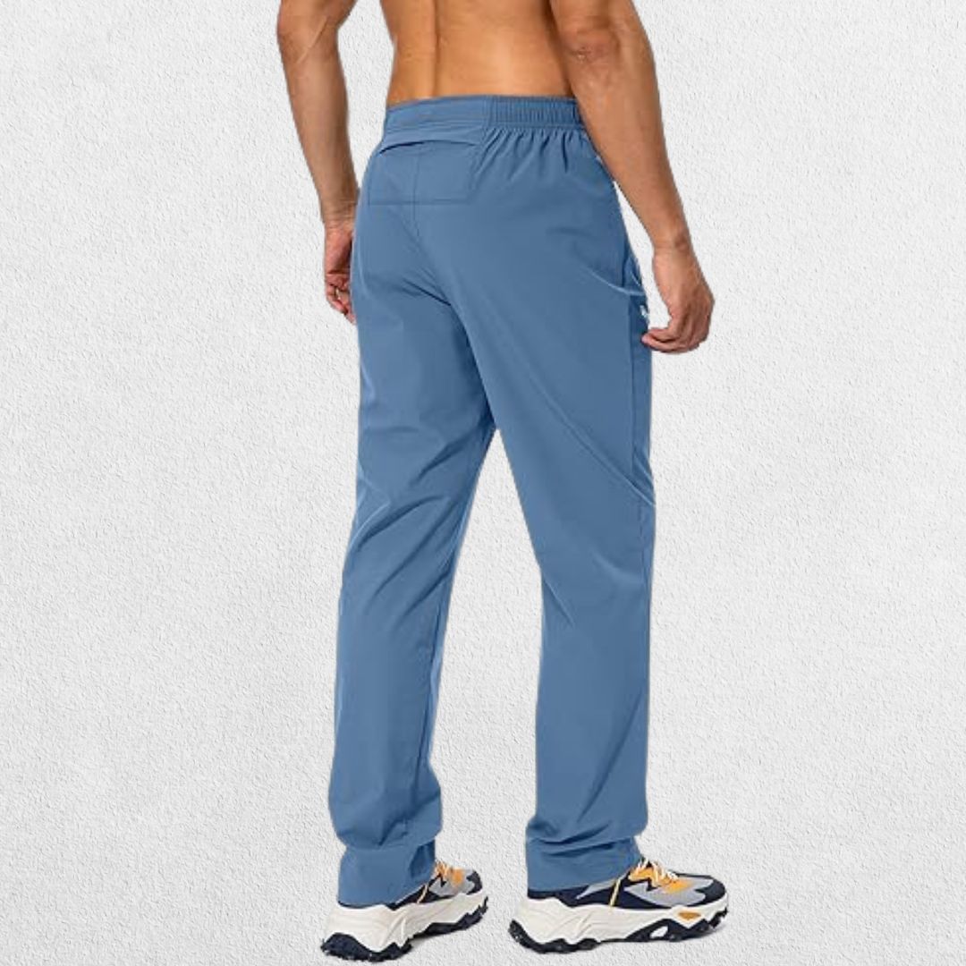 Back view of men's lichen blue workout trousers showcasing the durable fabric and versatile design for active performance.