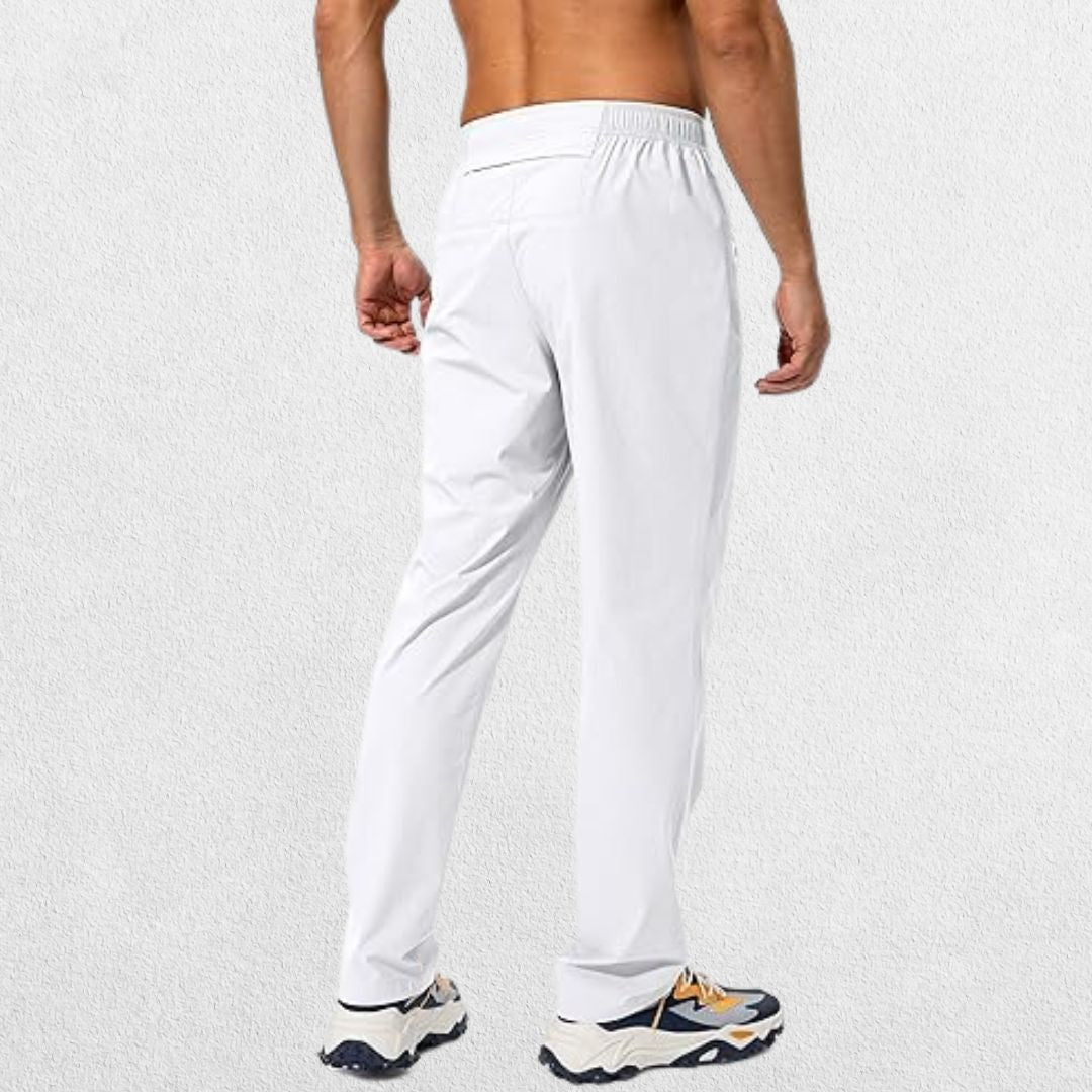 Men’s white athletic trousers with elastic waistband and zipper pockets, back view highlighting fit and design.