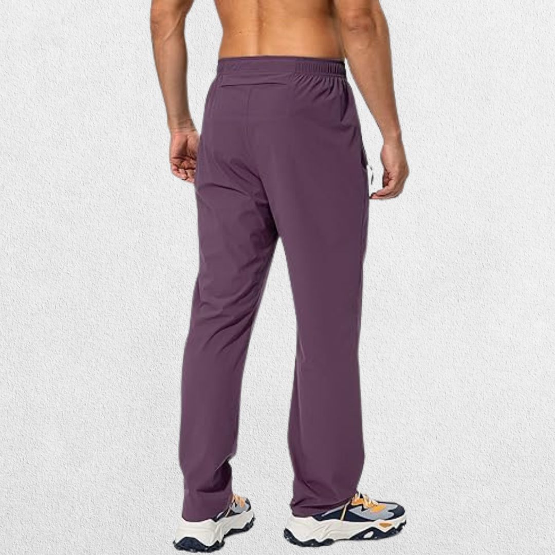 Eggplant-colored men’s athletic trousers with elastic waistband and secure zipper pockets, perfect for workouts.