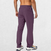 Eggplant-colored men’s athletic trousers with elastic waistband and secure zipper pockets, perfect for workouts.