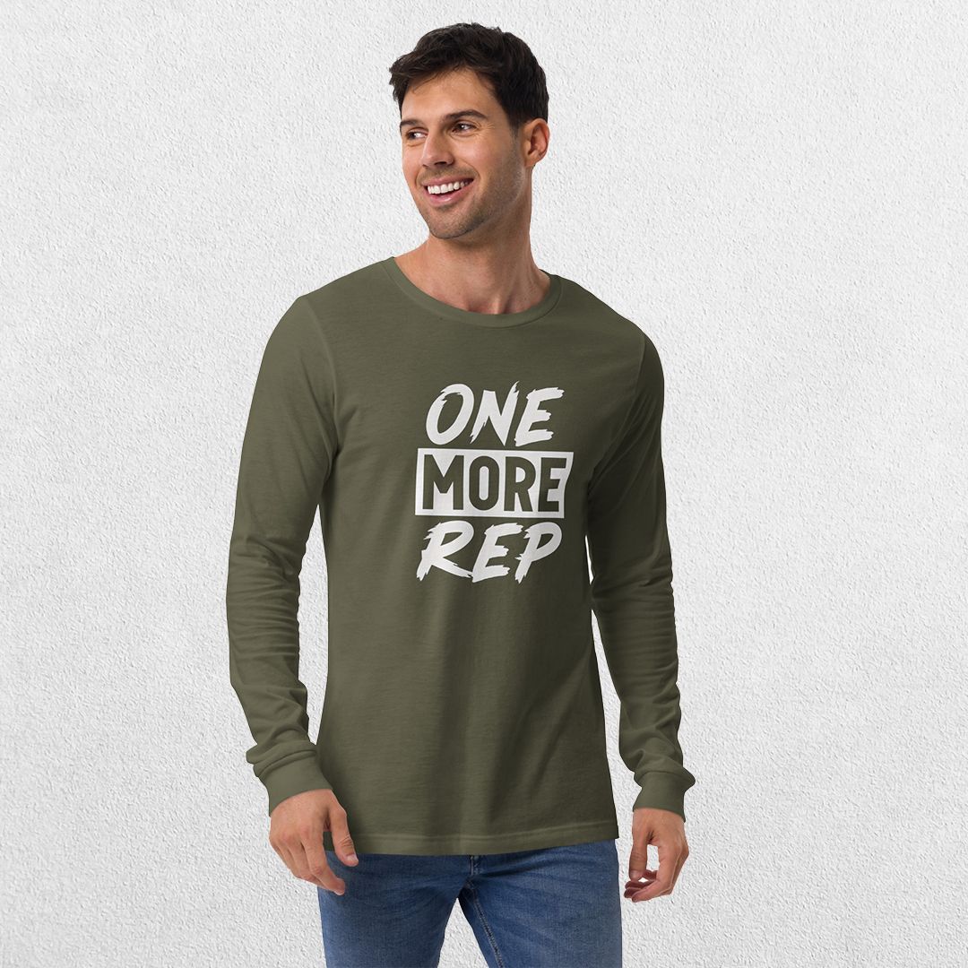 Model wearing the Military Green GPW One More Rep Unisex Motivational Long Sleeve Tee with jeans in studio background.
