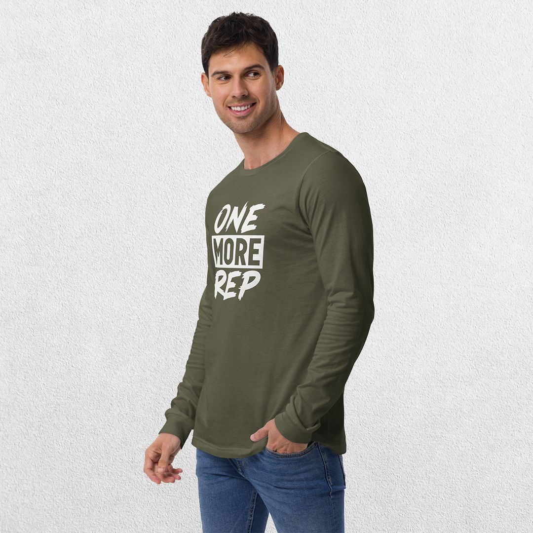 Model wearing the Military Green GPW One More Rep Unisex Motivational Long Sleeve Tee with jeans in studio background.