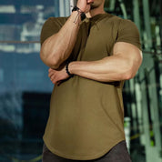 Model wearing an army green Muscle Fitness Summer T-Shirt in an outdoor gym setting.