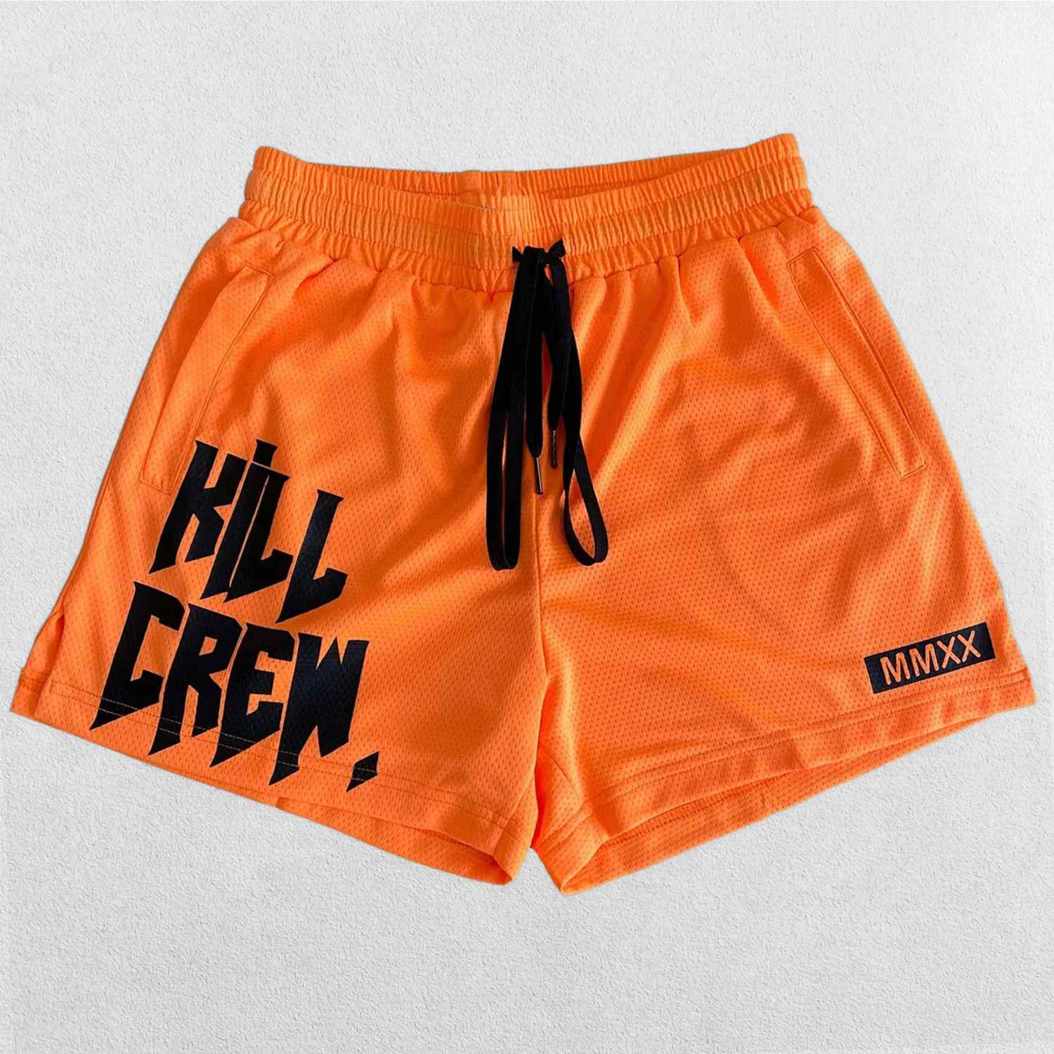 Close-up of Orange bold Kill Crew graphic print on GPW gym shorts.