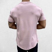 Close-up of Pink GPW Men's Fit Summer Gym T-Shirt - Bodybuilding Streetwear Tee in a studio background