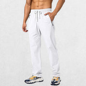 White Men’s Athletic Trousers with elastic waist and secure zipper pockets, designed for flexibility and comfort.