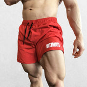 Model wearing Red GPW Men's Quick-Dry Fitness Shorts - Loose Beach Workout Bottoms