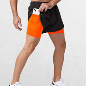 Side profile of the GPW High-Performance Men’s Running Shorts in fluorescent orange, emphasizing the breathable fabric and flexible fit with a neutral studio backdrop.