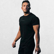 Side view of the GPW High-Performance Workout T-Shirt in black, emphasizing the stretchable material and ergonomic fit with a neutral studio backdrop.