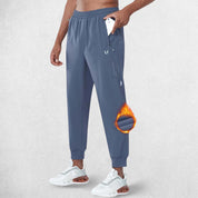 Side Pose of Model Wearing Smoke Grey GPW Men's Fleece Trousers Athletic Warm Winter Workout Pants with Pockets in a studio background